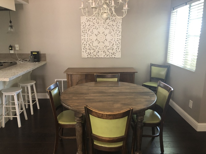 A dining room with a wooden table and chairs.