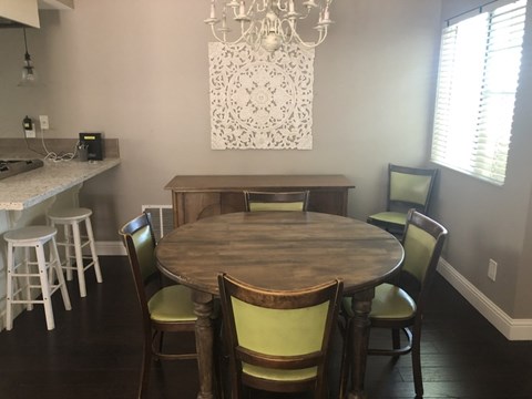 A dining room with a wooden table and chairs.