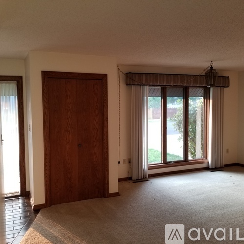 A room with a large window and a door.