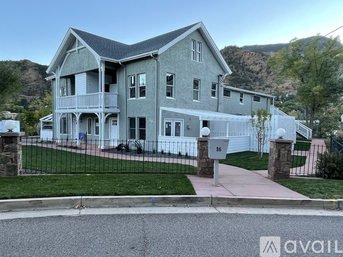 A large house with a mountain in the background and a sign that says "AVAILABLE".