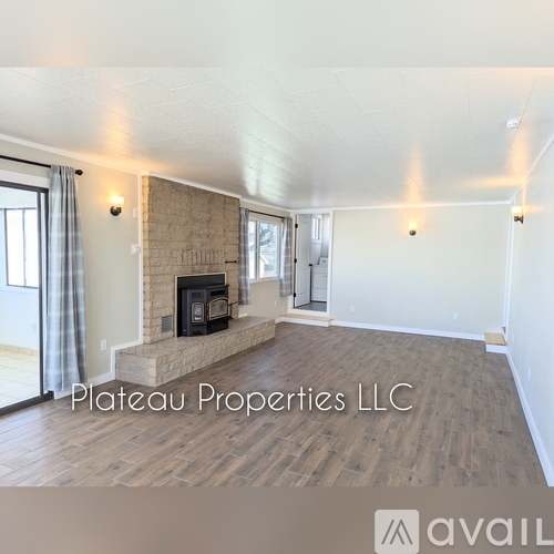 A living room with a fireplace and wood flooring.