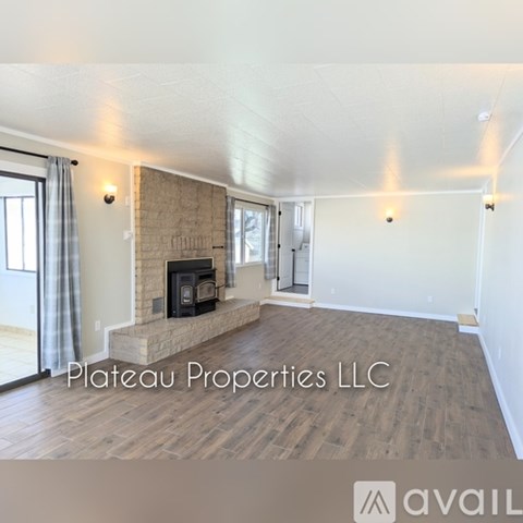 A living room with a fireplace and wood flooring.