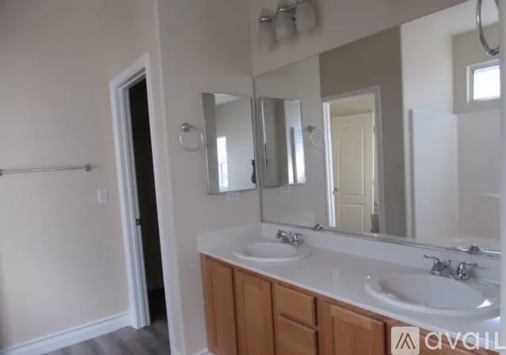 A bathroom with a white countertop and a mirror above the sink.