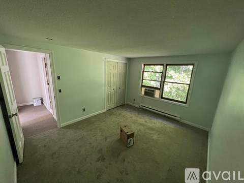 A room with a window and a door is available for rent.