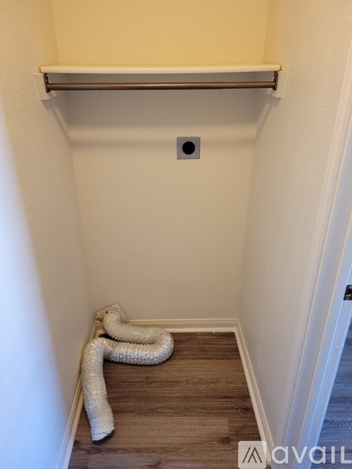 A white pipe runs along the floor of a hallway.