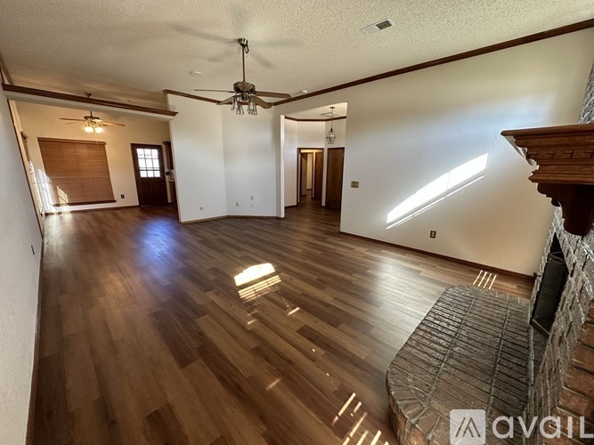 A living room with a wooden floor and a ceiling fan.
