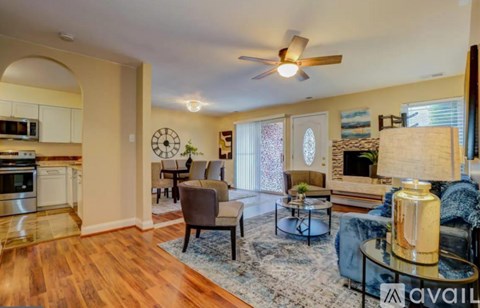 A living room with a wood floor and a ceiling fan.