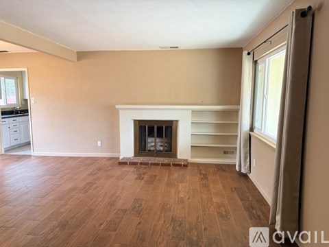 A living room with a fireplace and wooden flooring.