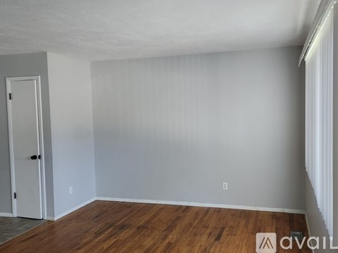 A room with wooden flooring and a white door.