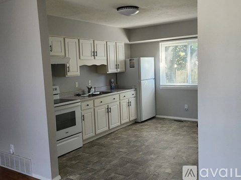 A kitchen with white cabinets and a tile floor.