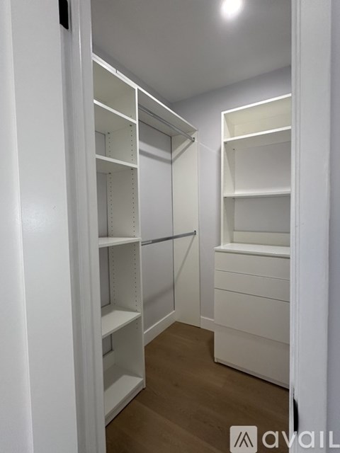 A white walk-in closet with shelves and a rope barrier.