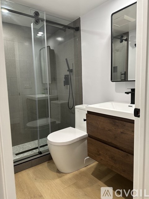 A modern bathroom with a toilet, sink, and shower.