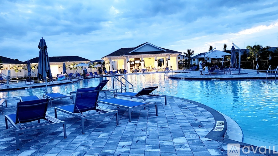 A poolside area with lounge chairs and umbrellas.