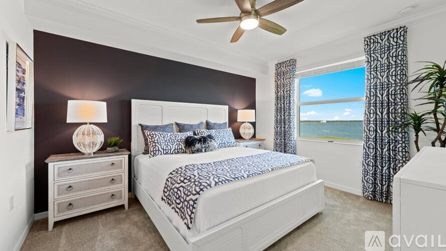 A bedroom with a large bed and a ceiling fan.