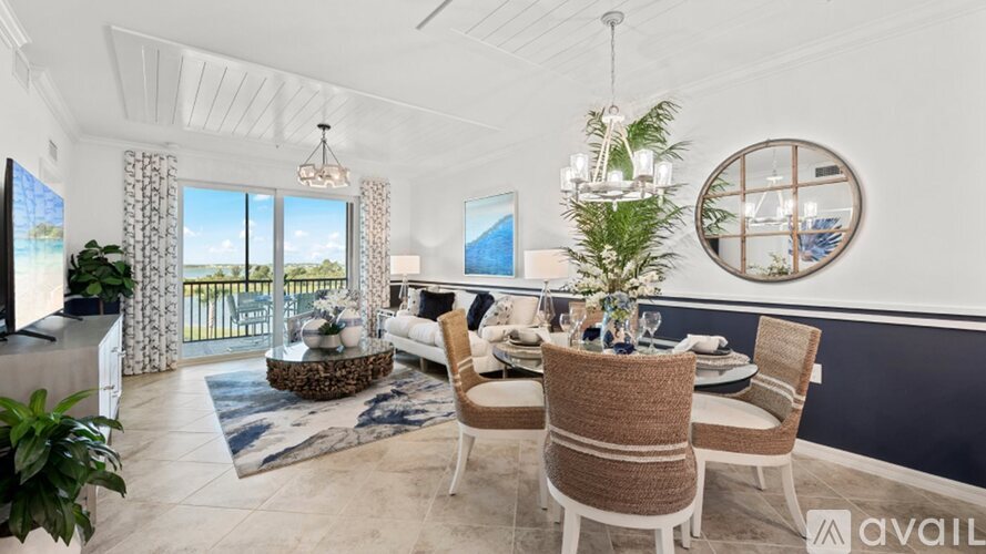 A dining room with a table set for six and a view of the ocean.