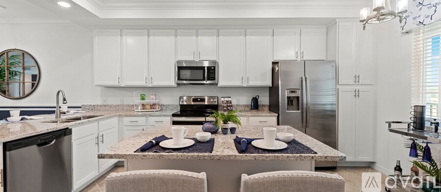 A modern kitchen with white cabinets and a granite countertop.