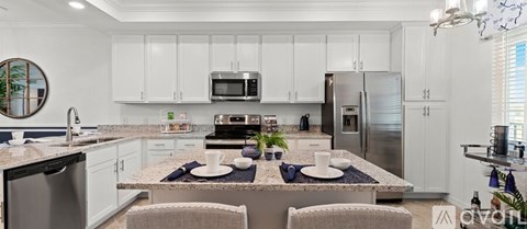 A modern kitchen with white cabinets and a granite countertop.