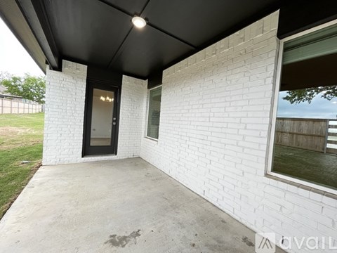 A white brick house with a black door and window.