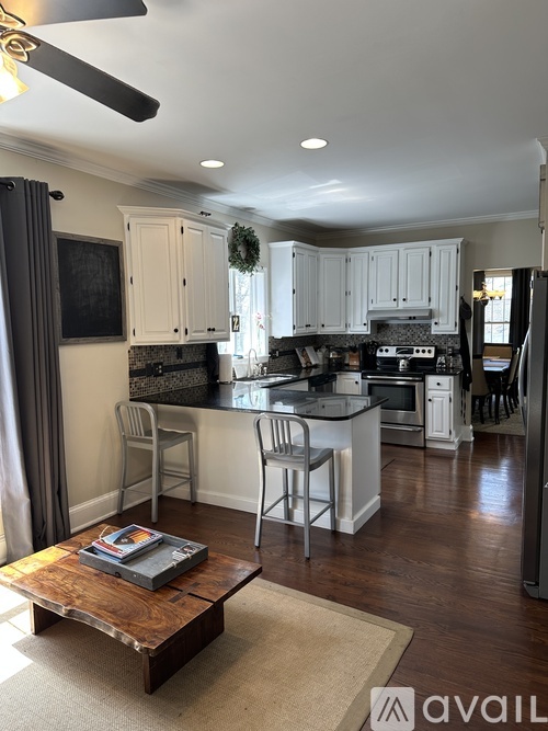 A modern kitchen with white cabinets and a wooden coffee table.