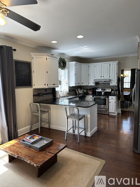 A modern kitchen with white cabinets and a wooden coffee table.