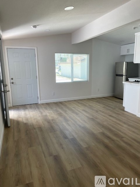 A room with wooden flooring and white walls.