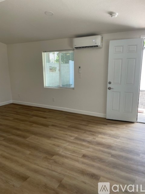 A room with a white door and a window with blinds.