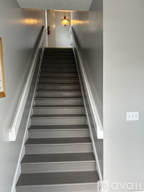 A staircase with a light switch on the wall.