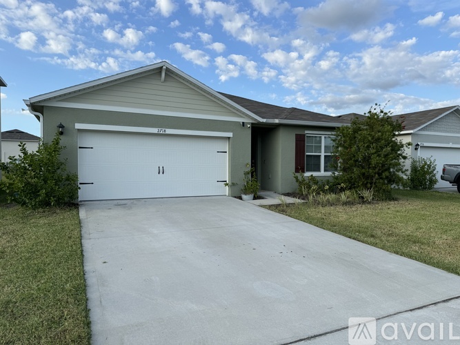 A house with a garage and a driveway in front.