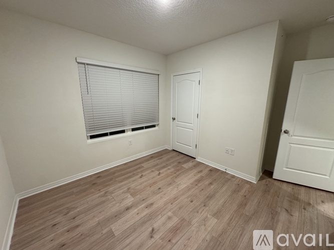 A room with wooden flooring and white walls.
