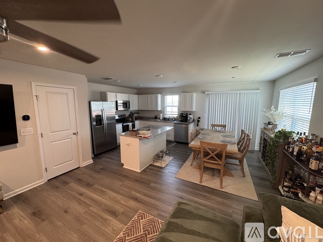 A well-lit kitchen with a dining table and chairs.