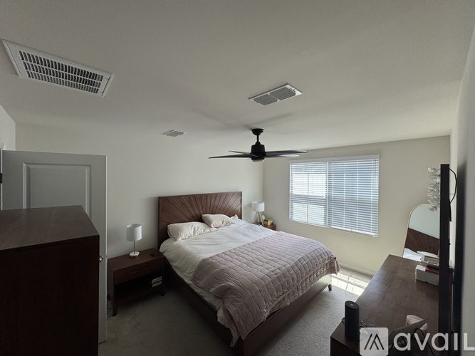 A bedroom with a bed, nightstand, and window.