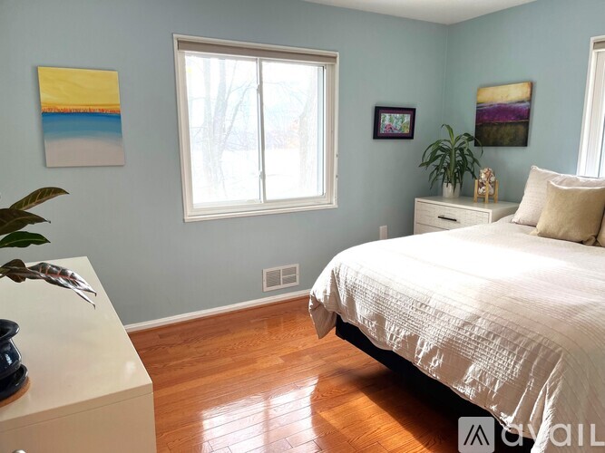 A bedroom with a bed, dresser, and two framed pictures on the wall.