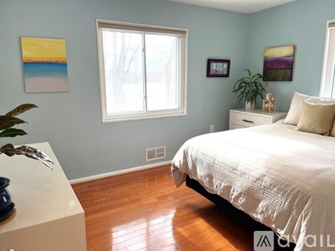 A bedroom with a bed, dresser, and two framed pictures on the wall.