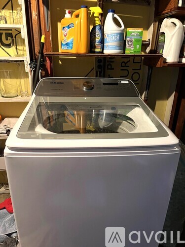 A white washing machine with a transparent door is in the foreground.