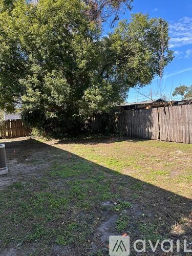 A backyard with a wooden fence and trees.