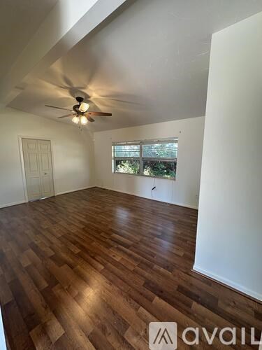 A room with wooden flooring and a ceiling fan.