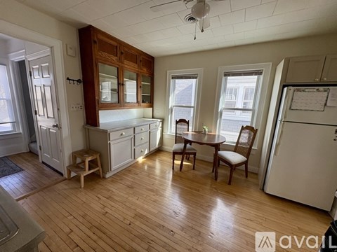 A kitchen with wooden floors and white walls.