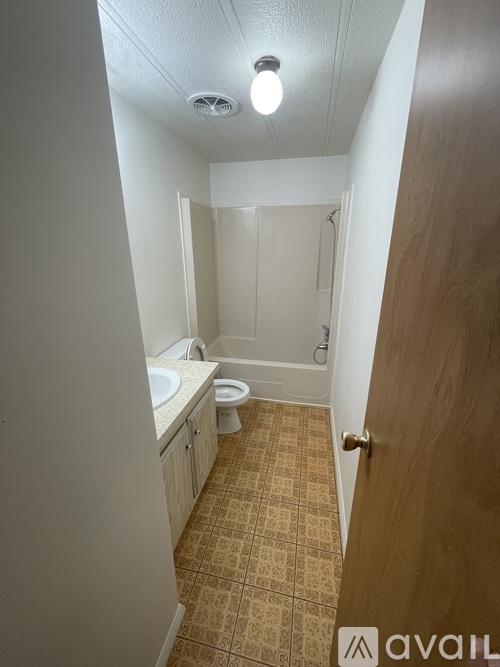 A bathroom with a toilet, sink, and shower.