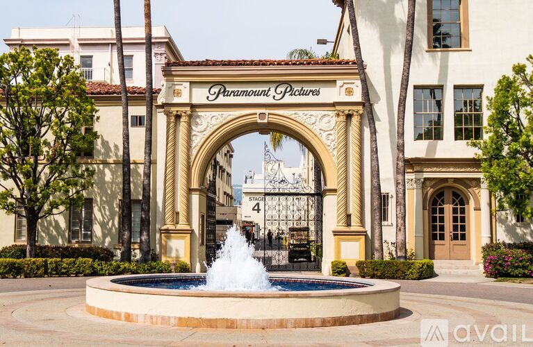 A fountain in front of a building entrance with the sign "Paramount Pictures" above it.