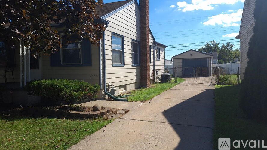 A sunny day in a residential area with houses and a clear sky.