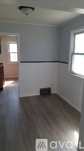 A room with wooden flooring and white walls.