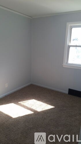 A room with a window and carpeted floor.