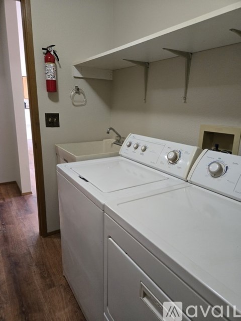 A white washing machine and dryer in a laundry room.