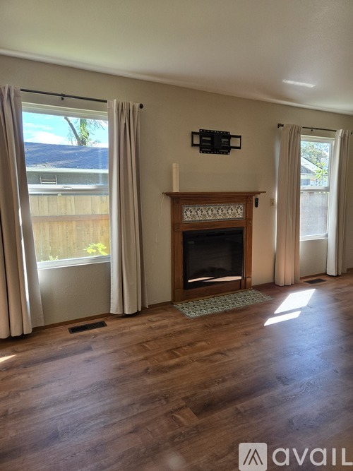 A living room with a fireplace and a flat screen TV mounted above it.