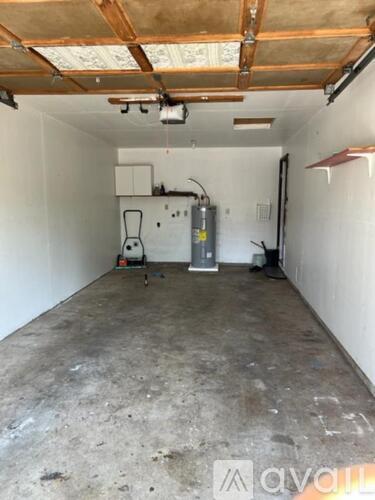 A room with a white wall and a grey floor.