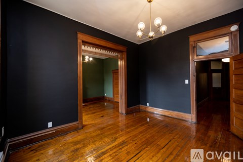 A room with wooden floors and a chandelier.