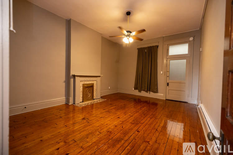 A room with a fireplace and wooden floors.