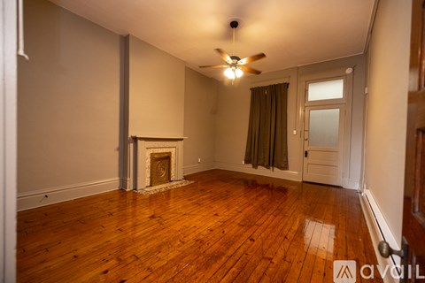A room with a fireplace and wooden floors.