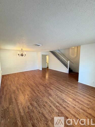A room with wooden flooring and a chandelier.