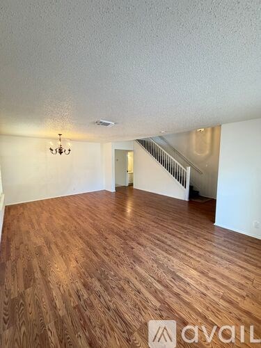 A room with wooden flooring and a chandelier.